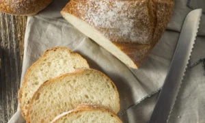 A freshly baked white bread loaf that's been sliced by hand